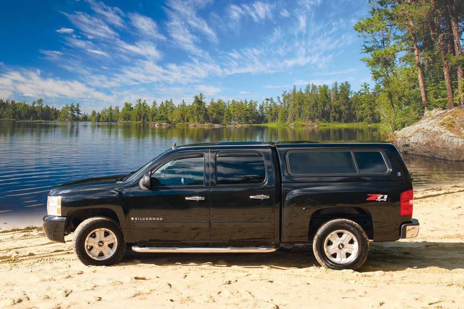 Century Ultra fiberglass truck cap on a Chevrolet Silverado near a lake