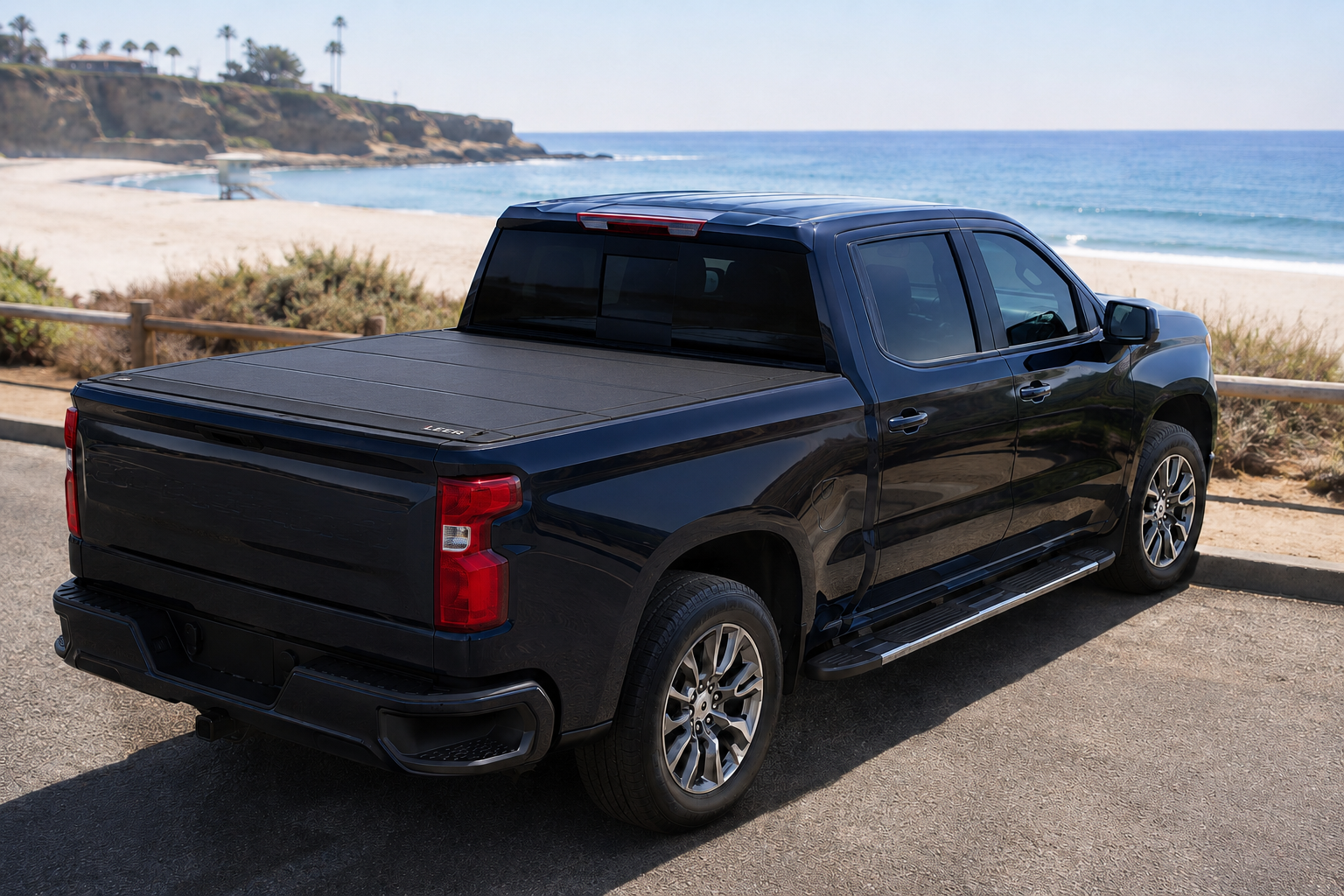 Pickup with a closed LEER HF650M parked beside the beach