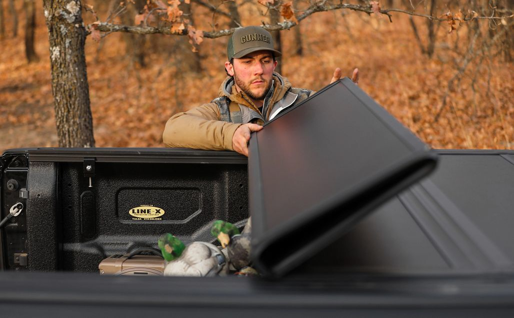 Person folding the LEER HF650M over a loaded truck bed