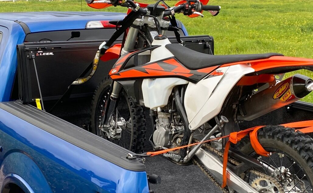 Dirt bike secured in a truck bed with the LEER HF650M upright