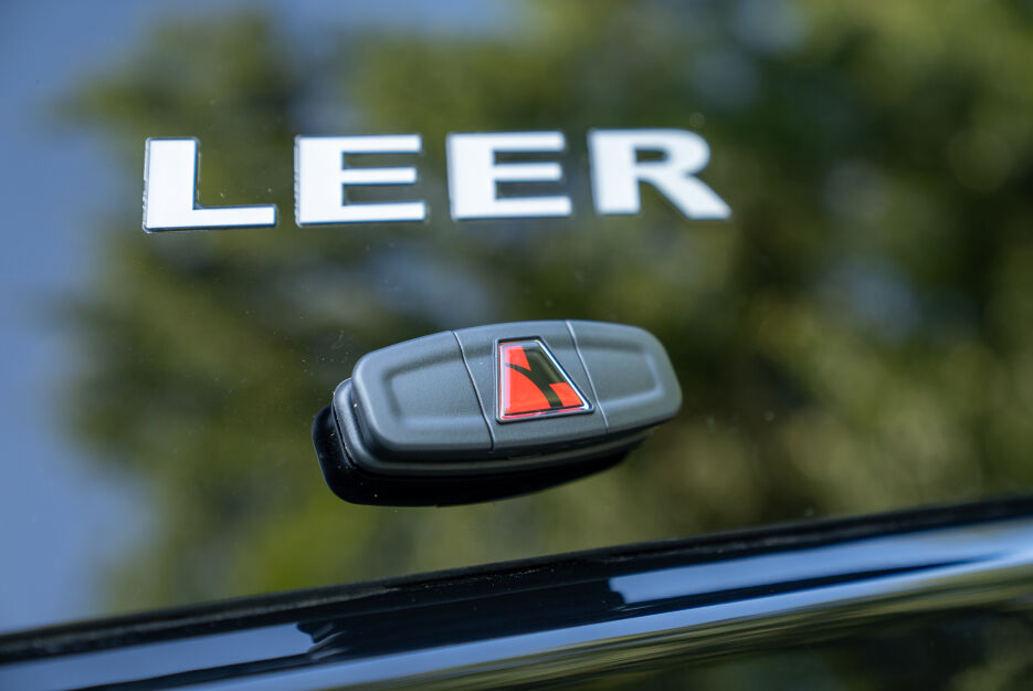 LEER-branded truck cap key fob against a reflective truck window